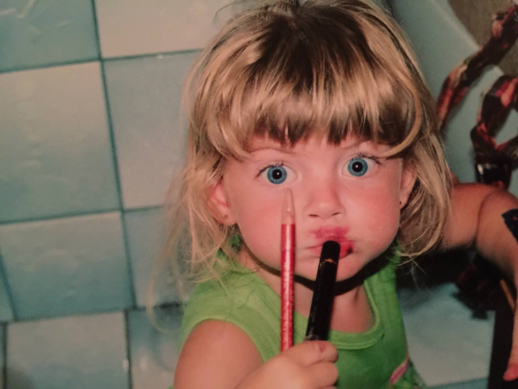 A childhood family snapshot with a playful makeup moment
